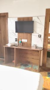 a wooden desk with a television on top of it at Mark inn hotel in Hanumāngarh