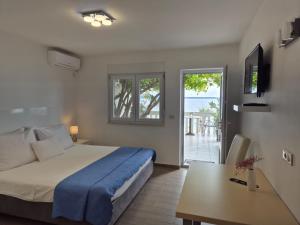 a bedroom with a bed and a table and a view of the ocean at Apartments Zanic on The Beach in Podstrana