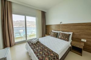 a bedroom with a large bed with a large window at La Moda Beach Hotel in Kaş