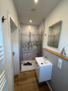 a bathroom with a white sink and a shower at MeerZeit 20 in Carolinensiel +25 photos