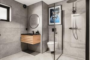 a bathroom with a shower and a toilet and a mirror at Trolltunga Stay - Mountain & Waterfall View in Odda +69 photos