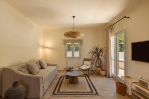 a living room with a couch and a tv at Anthos Villa in Kardhakáta
