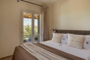 a bedroom with a large bed with a window at Anthos Villa in Kardhakáta +73 photos
