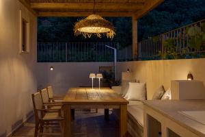a dining room with a table and a chandelier at Anthos Villa in Kardhakáta