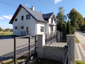a white house with a fence in front of it at Spełnienie Marzeń Bóbrka in Bóbrka