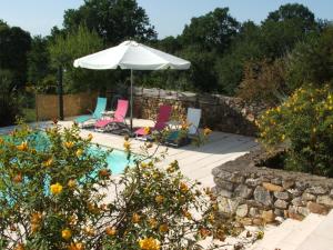 a patio with two chairs and an umbrella at La Zénitude in Les Lèches