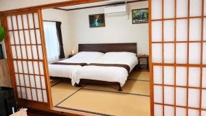 a bedroom with a bed and a mirror at Océanos - Sunset, BBQ, Beach & Kayak - オケアノス in Ishigaki Island