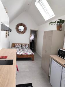 a small room with a bed and a kitchen at La maison du hérisson in Flines-lès-Mortagne +4 photos