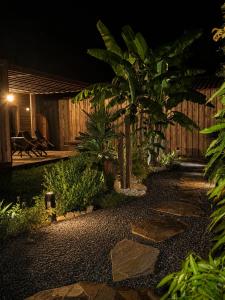 a garden at night with a wooden fence at Éco-Lodge avec son Spa Privatif in Mios