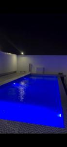 a large blue swimming pool in a room at night at D Avenue Studio in Iloilo City