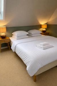 a bedroom with two beds with white sheets and pillows at Klippen Hotel - Skt Jørgens Gaard in Gudhjem