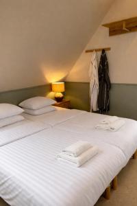 a bedroom with two beds with towels on them at Klippen Hotel - Skt Jørgens Gaard in Gudhjem +11 photos