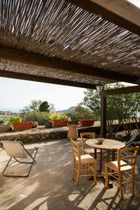a patio with a table and chairs under a roof at Il Mulino di Scauri in Pantelleria