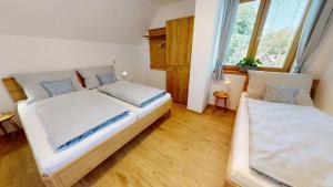 a bedroom with two beds and a window at Apartmány Nová Oleška in Huntířov