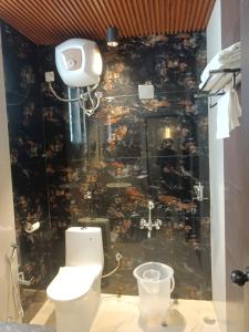 a bathroom with a shower with a toilet in it at SHELTER HOTEL in Lucknow +12 photos