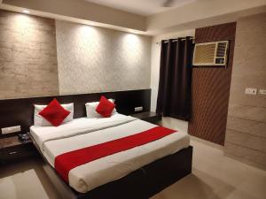 a bedroom with a large bed with red pillows at SHELTER HOTEL in Lucknow