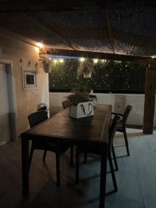 ein Holztisch in einem Raum mit Stühlen und Lampen in der Unterkunft Maison 5 in Pellaro