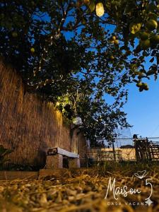 Eine Bank steht unter einem Baum neben einem Zaun in der Unterkunft Maison 5 in Pellaro + 15 Fotos