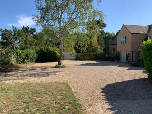 a tree in a yard next to a house at The Byre, at Cradle Barn offering a king suite in Abingdon