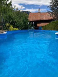 a large pool of blue water in front of a house at Patzberg Liesl in Dorfgastein +25 photos