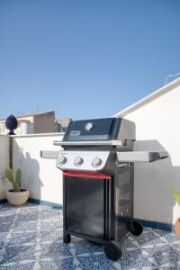 a grill on a balcony with a table on it at Zisa Top Romantic Terrace & Private outdoor Jacuzzi in Palermo