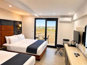a hotel room with two beds and a television at Kasr-ı Cihan Boutique Hotel in Midyat