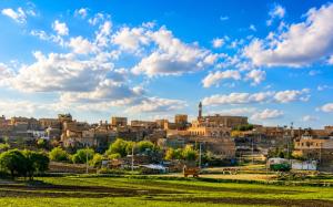 a cityscape of a city under a cloudy sky at Kasr-ı Cihan Boutique Hotel in Midyat +3 photos