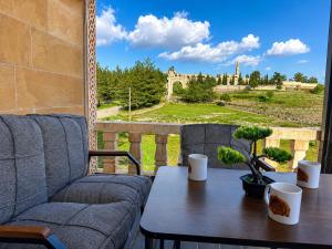 a couch and a table with a view of a castle at Kasr-ı Cihan Boutique Hotel in Midyat