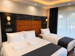 a hotel room with two beds and a window at Kasr-ı Cihan Boutique Hotel in Midyat