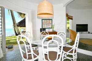 a dining room with a table and chairs and the ocean at Villa Eva in Belle Mare