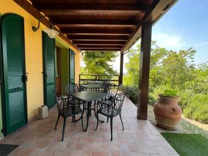 a patio with chairs and a table and a vase at Cortebella B&B Rimini in Vergiano