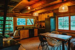 a kitchen and dining room with a table and chairs at River House in Nītaure