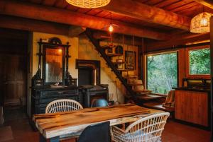 a dining room with a wooden table and a staircase at River House in Nītaure +56 photos