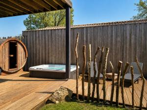a wooden deck with a hot tub and a fence at Éco-Lodge avec son Spa Privatif in Mios +27 photos