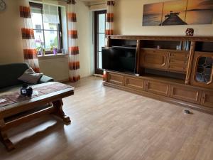 a living room with a couch and a tv at Uller`s Ferienwohnung im Usseltal in Daiting