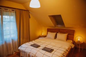 a bedroom with a bed with two towels on it at River House in Nītaure