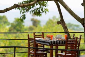a table with two chairs and a plate of food at Melheim Resort & Spa Haputale - An Infinite Escape into the Paradise in Haputale