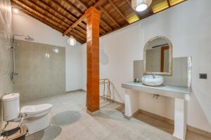 a bathroom with a toilet and a sink and a mirror at Wigus Villa Melasti in Ungasan +29 photos