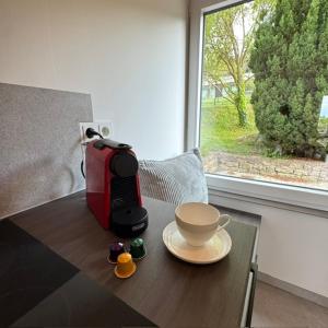 a coffee maker sitting on a table with a cup of coffee at Panorama Chalet Fahner Höhe nahe Erfurt mit Klimaanlage in Witterda
