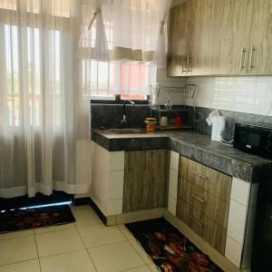 a kitchen with a sink and a counter top at BREEZEACARDEs in Diani Beach