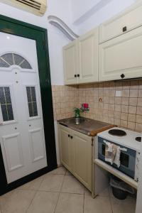 a kitchen with a white door and a stove at Empress Corfu in Perama