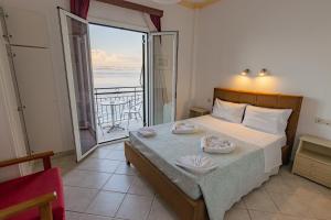 a bedroom with a bed with a view of the ocean at Empress Corfu in Perama