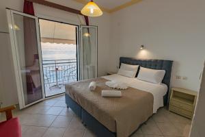 a bedroom with a bed with a view of the ocean at Empress Corfu in Perama +63 photos