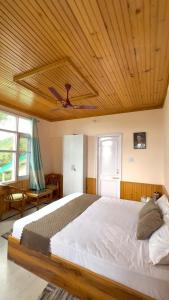 a bedroom with a large bed with a wooden ceiling at The Pahadi Ghar in Chail