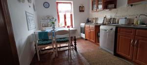 a kitchen with a table with chairs and a sink at Casa Szatina in Kishajmás