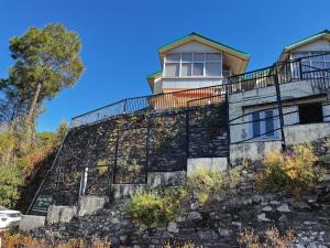 a house on top of a stone wall at The Pahadi Ghar in Chail