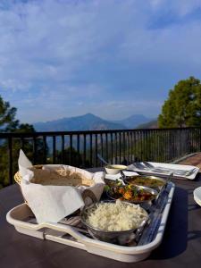 a tray of food on a table on a balcony at The Pahadi Ghar in Chail