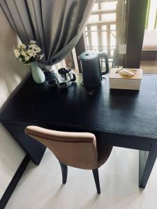 a black desk with a chair and a vase with flowers at Sea view apartments in Nathon Bay