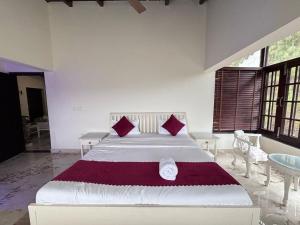a bedroom with a large white bed with red pillows at new vintage penthouse in Bhowāli