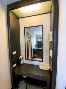 a mirror in a bathroom with a wooden table at Sea view apartments in Nathon Bay +6 photos